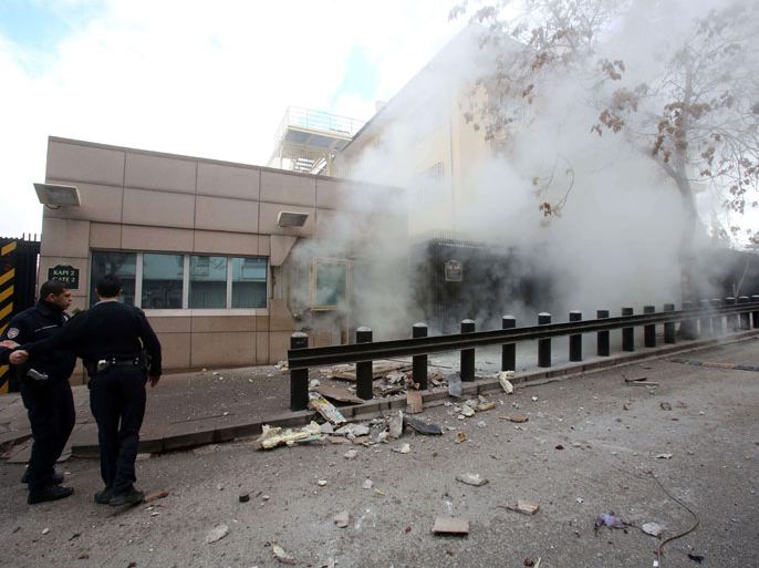 Ankara, Ankara, TURKEY : People stand outside the entrance of the US Embassy in Ankara just after a blast killed two security guards and wounded several other people on February 1, 2013. The United States confirmed on February 1 that its embassy in Ankara had been hit by a "terrorist" bomb attack and said American officials were working with Turkish investigators. "We can confirm a terrorist blast at a check point on the perimeter of our embassy compound in Ankara, Turkey, at 1:13 p.m. local time," State Department spokeswoman Victoria Nuland said in a statement. AFP PHOTO / YAVUZ OZDEN / MILLIYET NEWSPAPER