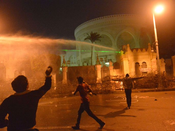 Egyptian security use water cannon as protesters throw stones into the grounds of the presidential palace in Cairo, on February 11, 2013, as the opposition held rallies to mark the second anniversary of former president Hosni Mubarak's overthrow. AFP PHOTO / KHALED DESOUKI