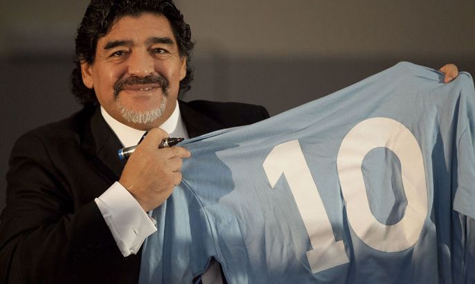 Football legend Argentinian Diego Maradona kisses a SSC Napoli number 10 jersey during a press conference on February 26, 2013 in Naples. Maradona, who rarely stepped foot in Italy since leaving under a cloud in the 1990s amid claims of collusion with mafia dons and a positive drugs test for cocaine, asked for "justice" in his dispute with Italian tax authorities on an emotional trip to Naples -- the scene of some of his greatest career successes. AFP PHOTO / CARLO HERMANN