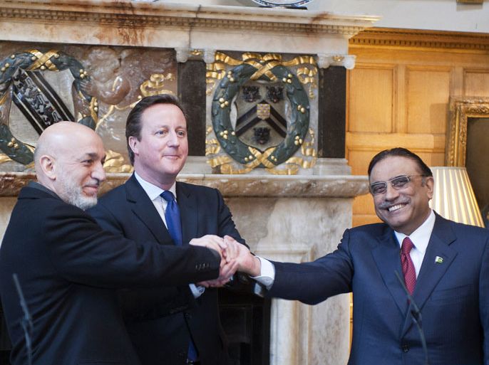 Britain's Prime Minister David Cameron (C) shakes hands with Afghan President Hamid Karzai (L) and Pakistani President Asif Ali Zardari (R) during trilateral talks at Chequers, the Prime Minister's official country residence, near Aylesbury in Buckinghamshire, west of London, on February 4, 2013. Karzai and Zardari vowed to achieve a peace settlement for Afghanistan within six months, after the talks hosted by Britain. AFP
