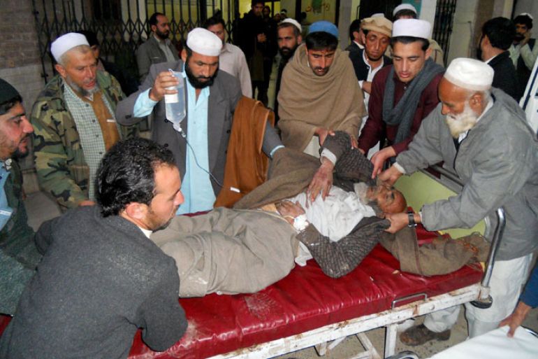 : Pakistani men move an injured bomb blast victim at a hospital in Kohat on February 8, 2013, after a bomb explosion in Orakzai district. Ten people were killed and another 26 wounded when a bomb exploded near a shop selling DVDs and mobile phones in Pakistan's northwestern tribal belt on Friday, officials said. AFP PHOTO/STR