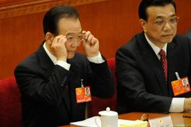Chinese Premier Wen Jiabao adjusts his glasses during the opening session of the Chinese National People's Congress (NPC) at the Great Hall of the People in Beijing on March 5, 2013. Wen Jiabao on March 5 targeted 2013 growth of 7.5 percent and vowed an unwavering fight against corruption as the world's second-largest economy opened its annual parliamentary session. AFP PHOTO / WANG ZHAO