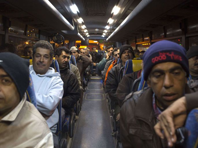 Palestinians sit in a bus as a new line is made available by Israel to take Palestinian labourers from the Israeli army crossing Eyal, near the West Bank town of Qalqilya, into the Israeli city Tel Aviv, on March 4, 2013.Thousands of Palestinians enter Israel to work every day after receiving permits, many of them in private vans. The new line will not be available for Jewish settlers. AFP PHOTO / MENAHEM KAHANA
