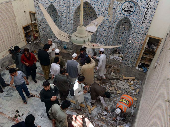 Peshawar, -, PAKISTAN : Local Pakistani residents and volunteers inspect a mosque following a bomb explosion in Peshawar on March 9, 2013. A bomb explosion inside a Sunni Muslim mosque killed four people and wounded 28 others in Pakistan's northwestern city of Peshawar, officials said