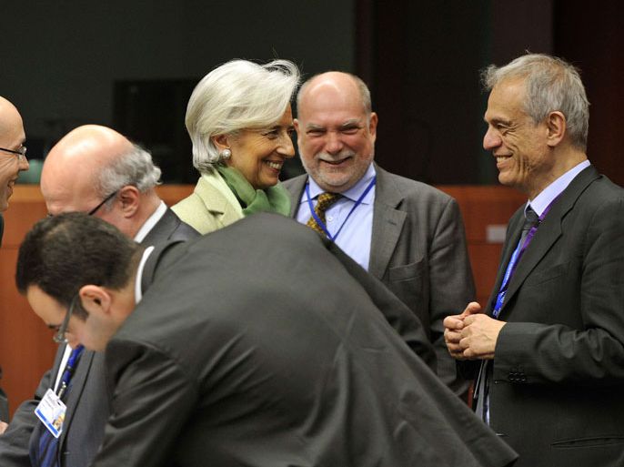 International Monetary Fund Managing Director Christine Lagarde (C) and Cypriot Finance Minister Michael Sarris (R) arrive prior to a Eurozone meeting on March 15, 2013 at the EU Headquarters in Brussels. Finance ministers of the euro zone were expected late on March 15 afternoon to try to complete the plan of aid to Cyprus, wishing to obtain the eurozone and the IMF loan of 17 billion euros the equivalent of the gross domestic product. AFP PHOTO / GEORGES GOBET