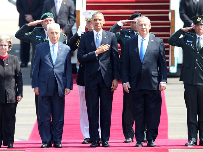 US President Barack Obama (C), Israeli Prime Minister Benjamin Netanyahu (R) and President Shimon Peres (L) listen to the national anthem at Israel’s Ben Gurion airport on March 20, 2013 upon Obama's arrival. Obama arrived in Israel for the first time as US president, hoping to ease past tensions with his hosts and under pressure to narrow differences over handling Iran's nuclear threat. AFP PHOTO/JACK GUEZ