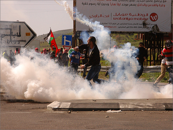 شباب يرشقون جنود الاحتلال بقنابله خلال مواجهات على حاجز حواره (الجزيرة نت) 