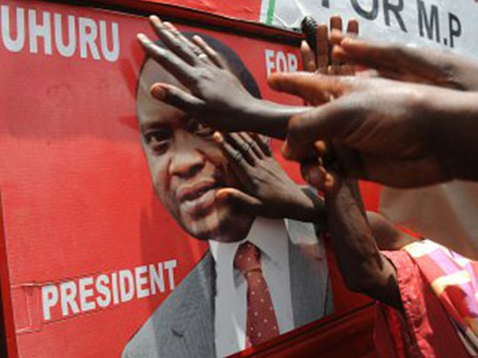 Supporters of Kenyan presidential candidate Uhuru Kenyatta touch his picture on an election poster as they celebrate upon learning of his victory in Kenya's national elections on March 9, 2013 in Kiambu, north of Nairobi- getty images