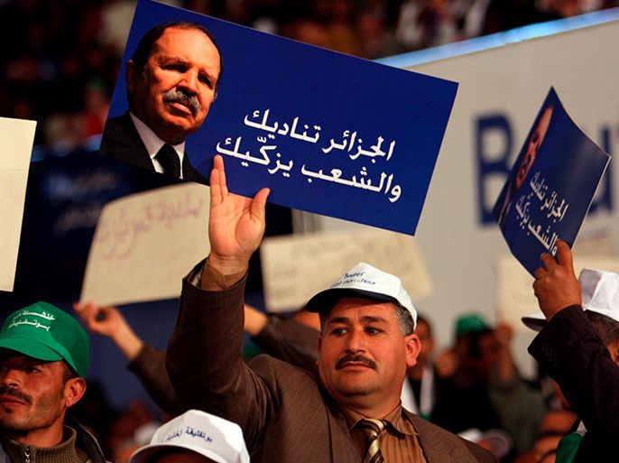 epa01670418 Supporters of the Algerian President Abdelazziz Bouteflika hold placards with a photograph of the President reading "Algeria callls you, and supports you", during a Presidential election campaign rally in Batna, some 450 km east of Algiers, Algeria, 19 March 2009. The presidential elections are scheduled for 09 April 2009. Official campaigning in Algerian elections started on 19 March with 6 candidates vying for the presidency including incumbent president Bouteflika. EPA/STF