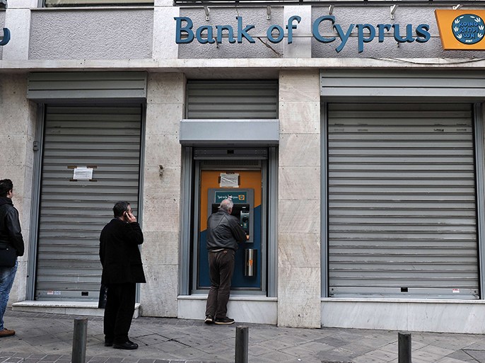 People queue to withdraw money from a Bank of Cyprus branch' ATM in Athens on March 19, 2013 while Cypriot banks remain closed in Greece until March 21. Athens was "ready" to absorb the subsidiaries of three Cyprus banks active in Greece, the Greek finance minister said as the eurozone sought to amend a controversial levy on the island nation's bank deposits. AFP PHOTO / LOUISA GOULIAMAKI