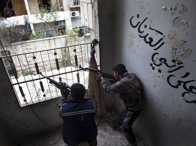 Syrian rebels aim their weapons as they take position in a building during clashes with regime forces in the Salaheddine district of Aleppo in northern Syria on March 16, 2013. As Syria's devastating conflict enters its third year, Britain and France are struggling to persuade their EU partners to ease the bloc's embargo and allow arms shipments to the rebels. AFP PHOTO/JM LOPEZ