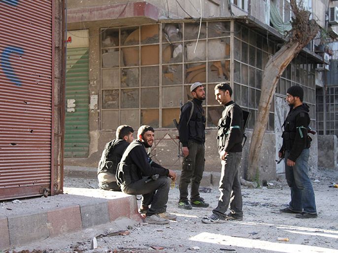 Free Syrian Army fighters sit on a sidewalk as others stand in Sidi Meqdad area in the suburbs of Damascus, March 27, 2013. Picture taken March 27, 2013. REUTERS/Ward Al-Keswani/Shaam News Network/Handout (SYRIA - Tags: CONFLICT CIVIL UNREST) ATTENTION EDITORS - THIS PICTURE WAS PROVIDED BY A THIRD PARTY. REUTERS IS UNABLE TO INDEPENDENTLY VERIFY THE AUTHENTICITY, CONTENT, LOCATION OR DATE OF THIS IMAGE. FOR EDITORIAL USE ONLY. NOT FOR SALE FOR MARKETING OR ADVERTISING CAMPAIGNS. THIS PICTURE IS DISTRIBUTED EXACTLY AS RECEIVED BY REUTERS, AS A SERVICE TO CLIENTS