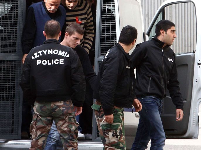 a dual Lebanese and Swedish citizen arrested in the port of Limassol in July last year and facing eight charges including conspiracy to commit a crime and participating in a criminal organisation, is escorted by police as he arrives at the court in the southern Cypriot coastal city of Limassol on March 21, 2013. The self-confessed Hezbollah militant told a court in Cyprus that he had collected information on Israeli tourists visiting the east Mediterranean island but denied plotting to attack them. AFP PHOTO / YIANNIS KOURTOGLOU