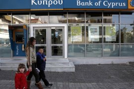A woman with children walks past a branch of Bank of Cyprus at Glyfada suburb in Athens March 17, 2013. Athens has started exploring local lenders' interest in taking over the Greek units of Cypriot banks, as part of the island's international bailout agreed earlier on Saturday, Greece's finance minister said. REUTERS/Yorgos Karahalis (GREECE - Tags: POLITICS BUSINESS)