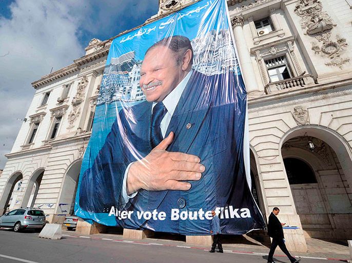 epa01672127 Algerian men walks past past a huge poster of Algerian President Abdelaziz Bouteflika in the centre of Algiers, Algeria, 21 March 2009. Six candidates, including incumbent head of state Abdelaziz Bouteflika, will take part in Algerias presidential elections on April 9. EPA/MOHAMED MESSARA