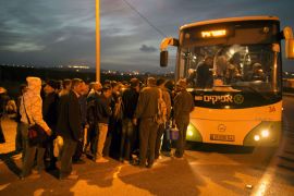 MK1178 - QALQILYA, WEST BANK, - : Palestinians queue to board a bus as a new line is made available by Israel to take Palestinian labourers from the Israeli army crossing Eyal, near the West Bank town of Qalqilya, into the Israeli city Tel Aviv, on March 4, 2013.Thousands of Palestinians enter Israel to work every day after receiving permits, many of them in private vans. The new line will not be available for Jewish settlers. AFP PHOTO / MENAHEM KAHANA
