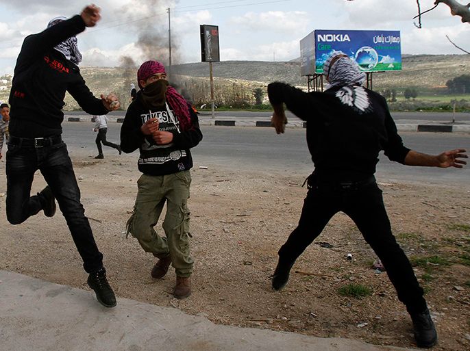 Palestinian protesters throw stones towards Israeli forces during clashes at Hawara checkpoint near the West Bank city of Nablus March 1, 2013. The death of a Palestinian prisoner in disputed circumstances in an Israeli jail last week, together with a hunger strike by four other Palestinian inmates, two of whom ended their protest on Wednesday after an agreement on their release was reached with Israel, have touched off violent protests over the past several weeks in the West Bank. REUTERS/Abed Omar Qusini (WEST BANK - Tags: POLITICS CIVIL UNREST MILITARY)
