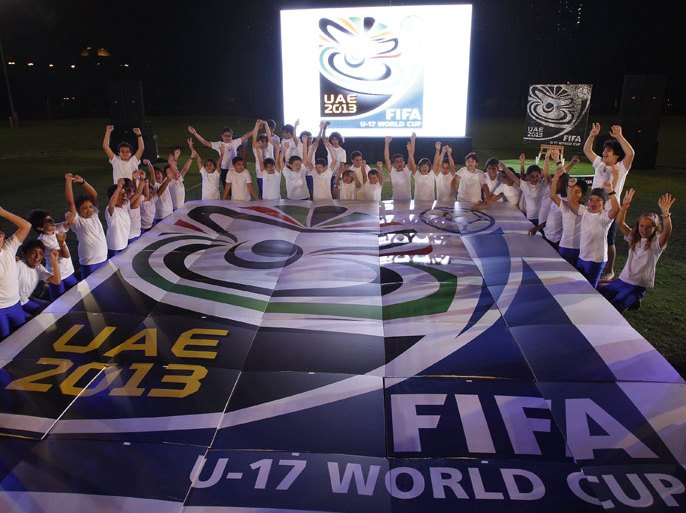 Children surround the official emblem of the FIFA U17 World Cup during an unveiling ceremony at the Emirates Palace in Abu Dhabi, on March 5, 2013. The 2013 U-17 World Cup will be held in the United Arab Emirates between October 17 and November 8. AFP PHOTO/STR