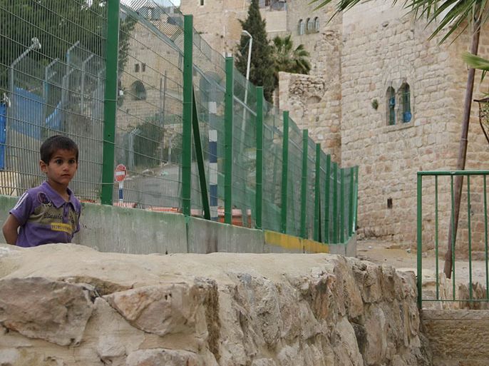 سياج يفصل مسلكا معبدا للمستوطنين (يسار) وممرا ضيقا للفلسطينيين (يمين)