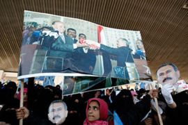 A girl holds up a poster, showing Yemen's former President Ali Abdullah Saleh handing over Yemen's national flag to his successor Abdo Rabbu Mansour Hadi, during a rally marking the first anniversary of Saleh's power transfer, in Sanaa, Wednesday.