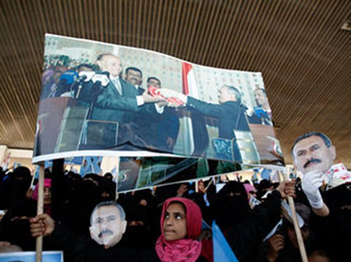 A girl holds up a poster, showing Yemen's former President Ali Abdullah Saleh handing over Yemen's national flag to his successor Abdo Rabbu Mansour Hadi, during a rally marking the first anniversary of Saleh's power transfer, in Sanaa, Wednesday.