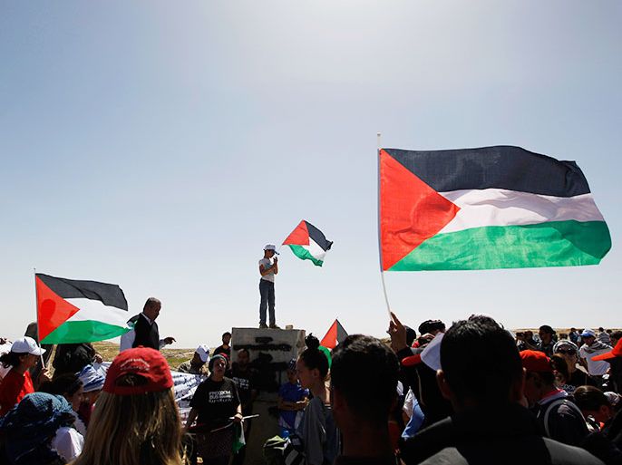Activists hold Palestinian flags at a rally marking Land Day in the West Bank village of al-Tuwani, south of Hebron March 29, 2013. Palestinian, Israeli and foreign activists took part in the rally which marks the annual commemorations in Israel of six Arab citizens killed by police in 1976 during protests against land confiscations in northern Israel's Galilee region. REUTERS/Ammar Awad (WEST BANK - Tags: POLITICS ANNIVERSARY CIVIL UNREST)