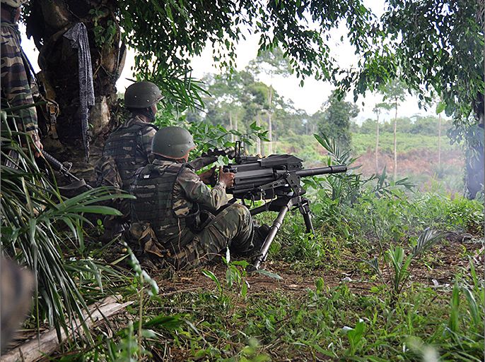 This handout picture taken on March 12, 2013 and released by Malaysia Ministry of Defence on March 13 shows Malaysian soldiers using a machine gun during a gunfight with alleged terrorists in the area of Sungei Nyamuk where Filipino gunmen were locked down in a stand off in the surrounding villages of Tanduo, in Sabah. Philippine armed intruders shot dead a Malaysian soldier on March 12, the first military fatality since security forces launched an assault one week ago to crush the Islamist gunmen. AFP PHOTO / Malaysia Ministry of Defence