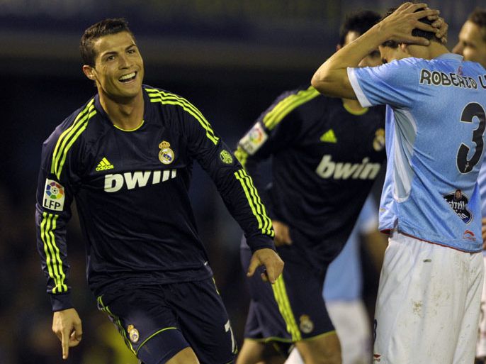 Real Madrid's Portuguese forward Cristiano Ronaldo (L) celebrates after scoring a goal during the Spanish league football match Celta vs Real Madrid at the Balaidos Stadium in Vigo, on March 10, 2013. AFP PHOTO / MIGUEL RIOPA
