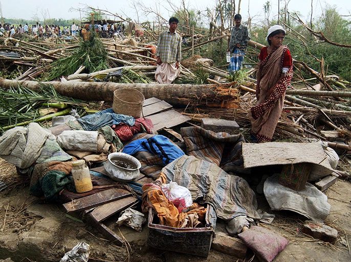 epa00172390 A Bangladeshi women looks for her belongings in the debris of her house in Kachanpur village of Netrokona district in northeastern Bangladesh on Thursday, 15 April 2004. At least 45 people died and hundreds others were injured as a powerful tornado reduced 16 villages in northeastern Bangladesh to rubble, local late on Wednesday, officials said Thursday. The twister struck overnight the northeastern districts of Mymensingh and Netrokona, leaving over 6,000 people homeless. Trees were uprooted, telephone links disrupted and dwellings were smashed by the tornado, which lasted for ten minutes. EPA/MUFTY MUNIR