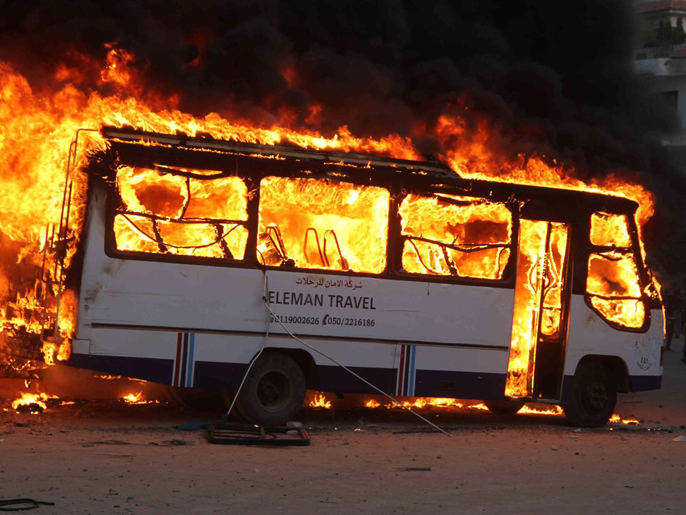 ‪المتظاهرون أحرقوا حافلات كانت تنقل الإخوان إلى المقطم‬  (الجزيرة)