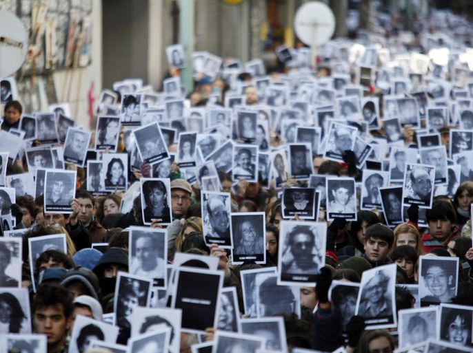 People holding photographies of victims participate at the ceremony to mark the 16th anniversary of the bomb attack against the Jewish Community Center (AMIA) in Buenos Aires, Argentina, 16 July 2010. The bombing, on July 18, 1994, caused the seven-story building of the Jewish-Argentine Mutual Association community center in Buenos Aires to collapse, killing 85 people and injuring another 300.