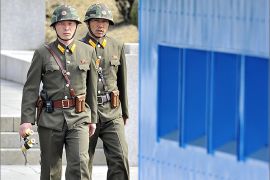North Korea soldiers walk on the North side at the truce village of Panmunjom in the demilitarized zone dividing the two Koreas on March 19, 2013. The US on March 19 said it was flying training missions of nuclear-capable B-52 bombers over South Korea, in a clear signal to North Korea at a time of escalating military tensions. AFP PHOTO / JUNG YEON-JE