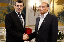 Tunisian President Moncef Marzouki (R) shakes hands with Prime Minister Ali Larayedh in Tunis March 8, 2013. Larayedh unveiled a new Islamist-led coalition government on Friday that he said would serve only until an election is held before the end of the year. REUTERS/Zoubeir Souissi (TUNISIA - Tags: POLITICS)