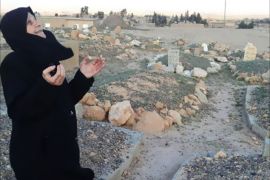 أرملة سورية تقف على قبر زوجها