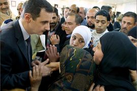 A handout picture from the Syrian Presidency Media Office shows Syrian President Bashar al-Assad (L) speaking with Syrian women during his surprise visit to the Educational Centre for Fine Arts in the capital Damascus on March 20, 2013. Assad made a visit to the centre where the education ministry was honouring the families of students who were martyred as a result of terrorist acts. AFP PHOTO/HO/SYRIAN PRESIDENCY MEDIA OFFICE === RESTRICTED TO EDITORIAL USE - MANDATORY CREDIT "AFP PHOTO / HO /SYRIAN PRESIDENCY MEDIA OFFICE " - NO MARKETING NO ADVERTISING CAMPAIGNS - DISTRIBUTED AS A SERVICE TO CLIENTS ==
