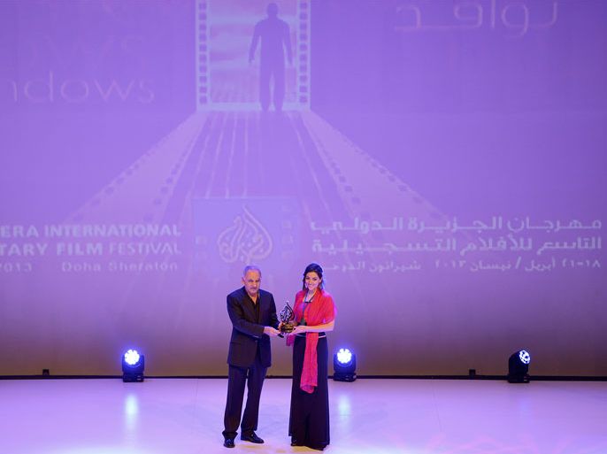 مدير مهرجان الجزيرة الدولي للافلام التسجيلية يسلم الجائزة للمخرجة الفائزة بفيلم "غضب السلحفاة" باري القلقيلي