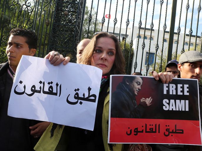 epa03518161 A Tunisian protester holds banners during a demonstration outside of Tunisian National Constituent Assembly to demand the liberation of Sami Fehri, TV producer and director of Ettounsiya Television, in Tunis, Tunisia, 26 December 2012. Fehri is facing corruption charges for his association with Belhassen Trabelsi, the brother-in-law of former president Zine el-Abidine Ben Ali