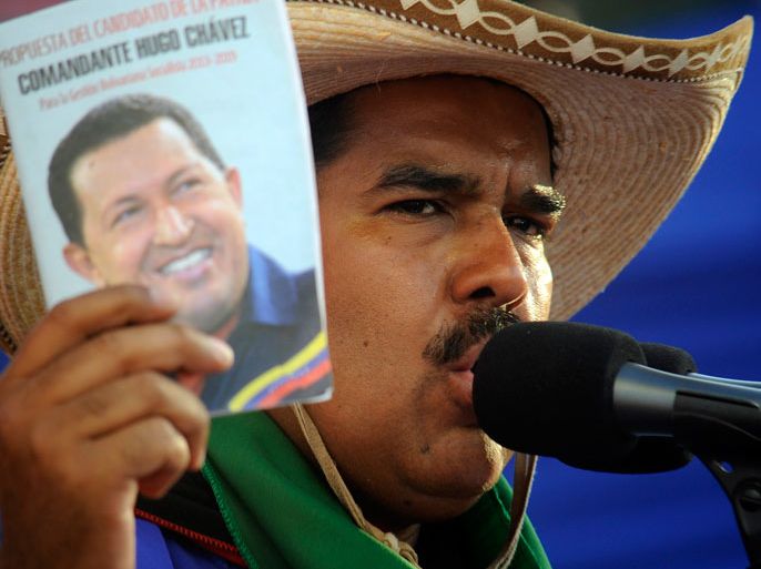 Venezuelan acting President and presidential candidate Nicolas Maduro, delivers a speech as he holds a booklet with the portrait of late Venezuelan President Hugo Chavez during a campaign rally in San Juan de los Morros, Guarico state, Venezuela on April 7, 2013. Venezuelans will elect new president next April 14. AFP /JUAN BARRETO