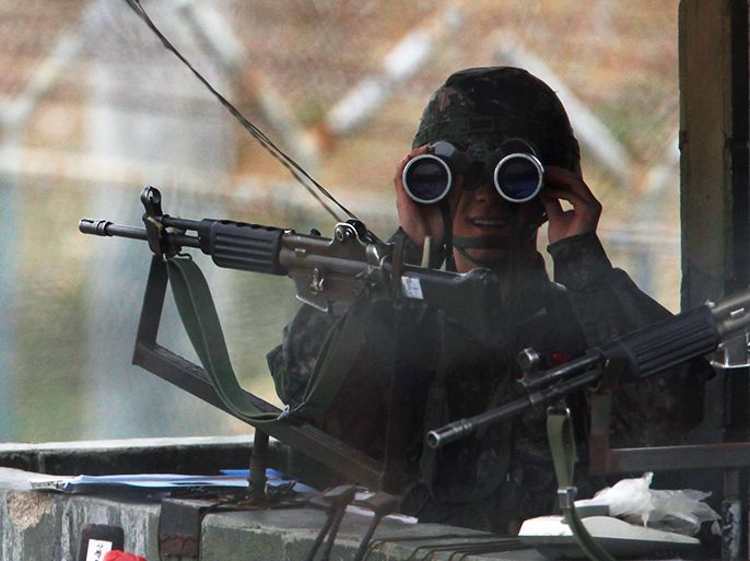 A South Korean soldier looks to the north through a pair of binoculars at an observation post near the demilitarized zone (DMZ) which separates the two Koreas in Paju, north of Seoul, April 5, 2013. North Korea's explicit threats this week to strike the United States with nuclear weapons are rhetorical bluster, as the isolated nation does not yet have the means to make good on them, Western officials and security experts say. REUTERS/Kim Hong-Ji (SOUTH KOREA - Tags: POLITICS MILITARY)