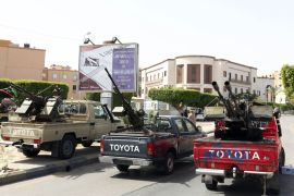 Vehicles, mounted with anti-aircraft guns are parked outside the foreign ministry that has been surrounded by gunmen demanding it be "cleansed of agents" and ambassadors of ousted dictator Moamer Kadhafi on April 28, 2013 in the Libyan capital Tripoli. The group prevented staff from entering the building said a ministry official who spoke to AFP. The General National Congress, Libya's highest political authority, is studying proposals for a law to exclude former Kadhafi regime officials from top government and political posts