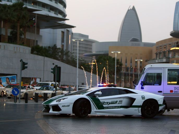 Emirati policemen patrol in a Lamborghini Aventador near Burj Khalifa in the Gulf emriate of Dubai on April 12, 2013. A sleek $550,000 Lamborghini Aventador, which can reach speeds of up to 349 km/h (217 mph), has joined the Dubai police deparment's fleet of patrol cars to enhance the glizty Gulf emirate's trademark image of luxury and prosperity