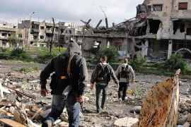 Free Syrian Army fighters walk in a destroyed neighbourhood in Homs April 5, 2013 in this picture provided by Shaam News Network. Picture taken April 5, 2013. REUTERS/Mohamed Ibrahim/Shaam News Network/Handout (SYRIA - Tags: POLITICS CIVIL UNREST CONFLICT MILITARY)