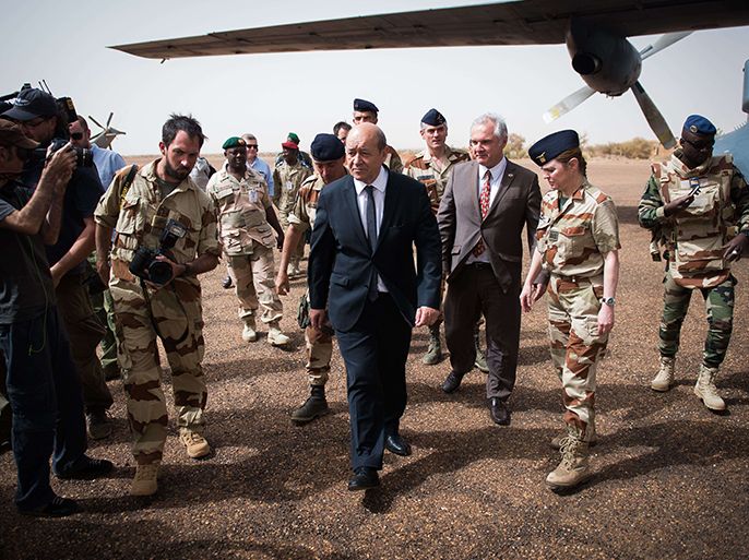 French Defence minister Jean-Yves Le Drian (C) arrives to visit soldiers of Serval Operation, on April 25, 2013 in French Army base of Gao. Le Drian arrived in Mali on the first leg of a tour of several countries to prepare for a post-war Mali. Mali called on France's help in January to halt an Islamist advance on Bamako and French and African troops have since pushed the Al-Qaeda-linked militants into desert and mountain hideouts, from where they are staging guerrilla attacks. AFP PHOTO MARTIN BUREAU