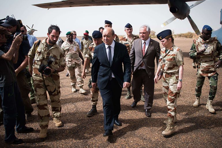 French Defence minister Jean-Yves Le Drian (C) arrives to visit soldiers of Serval Operation, on April 25, 2013 in French Army base of Gao. Le Drian arrived in Mali on the first leg of a tour of several countries to prepare for a post-war Mali. Mali called on France's help in January to halt an Islamist advance on Bamako and French and African troops have since pushed the Al-Qaeda-linked militants into desert and mountain hideouts, from where they are staging guerrilla attacks. AFP PHOTO MARTIN BUREAU