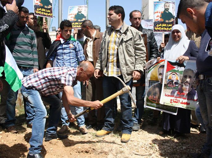 فلسطينيوني يحفرون قبورا رمزية لاسراهم المرضى