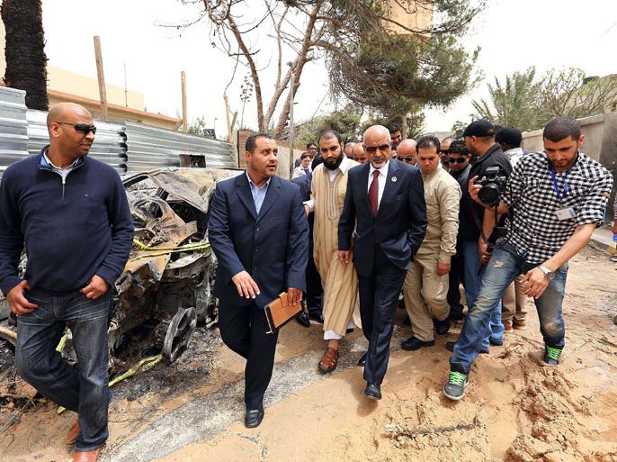 Tripoli, -, LIBYA : Libya's national Assembly president Mohamed Megaryef (C) visits the site of the eve French Embassy bombing, which wounded two French guards on April 25, 2013 in Tripoli, Libya. Security breaches preceded the bombing of the French embassy in Tripoli this week, the president of Libya's national assembly said, while adding that investigations into the attack were progressing. AFP PHOTO/MAHMUD TURKIA