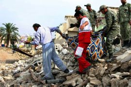 BEH065 - Shonbeh, -, IRAN : Iranian soldiers and aid workers help a man to carry his belongings salvaged from the rubble of his destroyed house in the town of Shonbeh, southeast of Bushehr, on April 10, 2013, a day after a powerful earthquake struck near the Gulf port city of Bushehr. Rescuers wound up operations after pulling 20 people from the rubble of a 6.1 magnitude earthquake, killing 37 people but sparing Iran's sole nuclear power plant. AFP PHOTO/STR