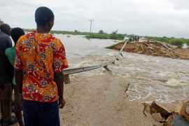 epa01913434 Villagers stand by a bridge washed away by floodwaters off near Malindi along the Indian Ocean coast line north of Mombasa, Kenya on 28 October 2009. At least one person died in the raging flood which has left hundreds of families homeless just weeks after the rains began as the region comes out of one of the most devastating droughts in years. EPA/STR