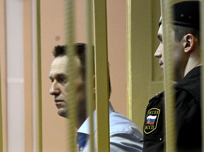 Kirov, -, RUSSIAN FEDERATION : Russian protest leader Alexei Navalny walks past a guard as he attends a hearing of his case in a court in the provincial northern city of Kirov on April 24, 2013. Navalny went today on trial on charges that he says were ordered by President Vladimir Putin in revenge for him daring to oppose the Kremlin. AFP PHOTO/KIRILL KUDRYAVTSEV