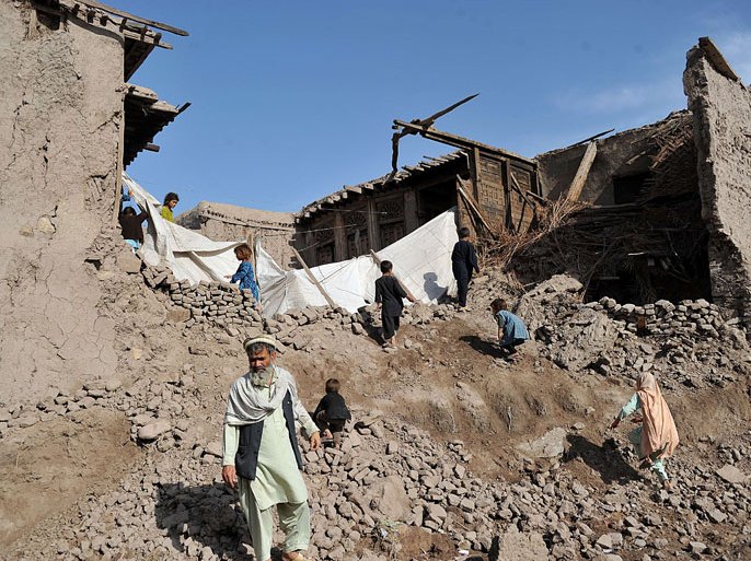 Afghan residents walk on a home destroyed by a powerful earthquake in Charbagh village in Nangarhar province on April 24, 2013. Seven people were killed, dozens injured and many homes destroyed when a powerful earthquake struck eastern Afghanistan on Wednesday, officials said. AFP PHOTO/ Noorullah Shirzada